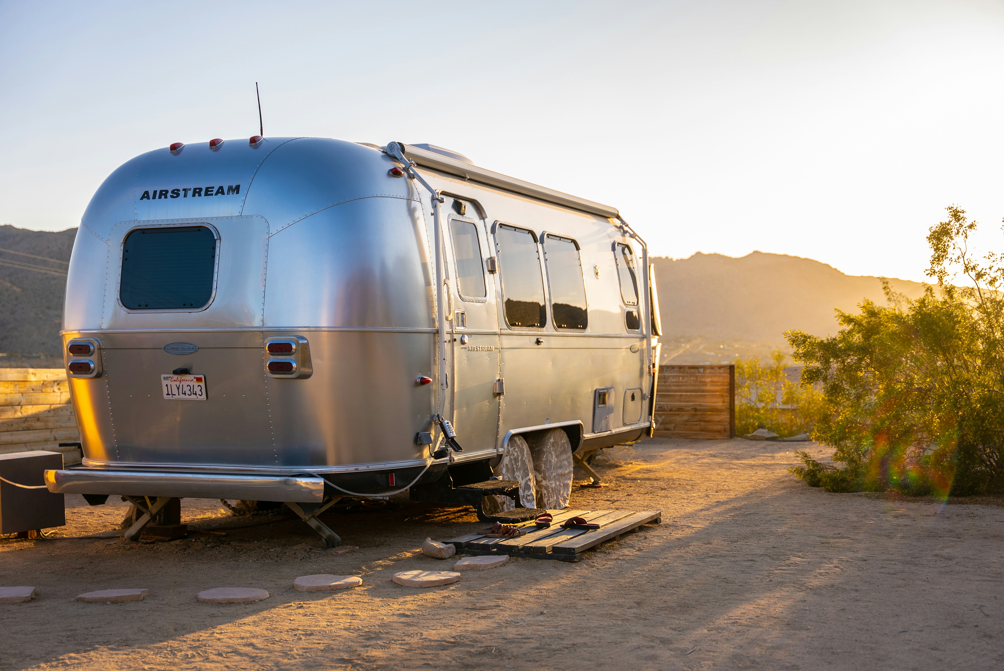 An airstream trailer parked in golden light
